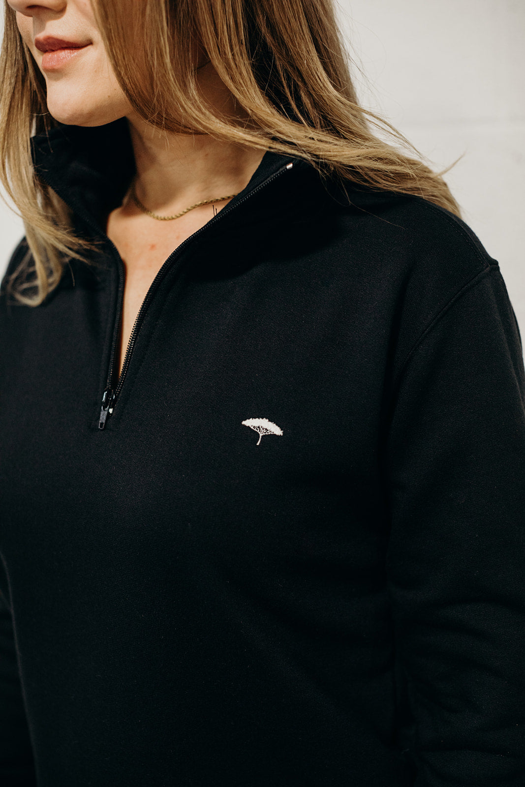 Unisex ethically made black 1/4 zip sweater with small white Ungalli tree on front