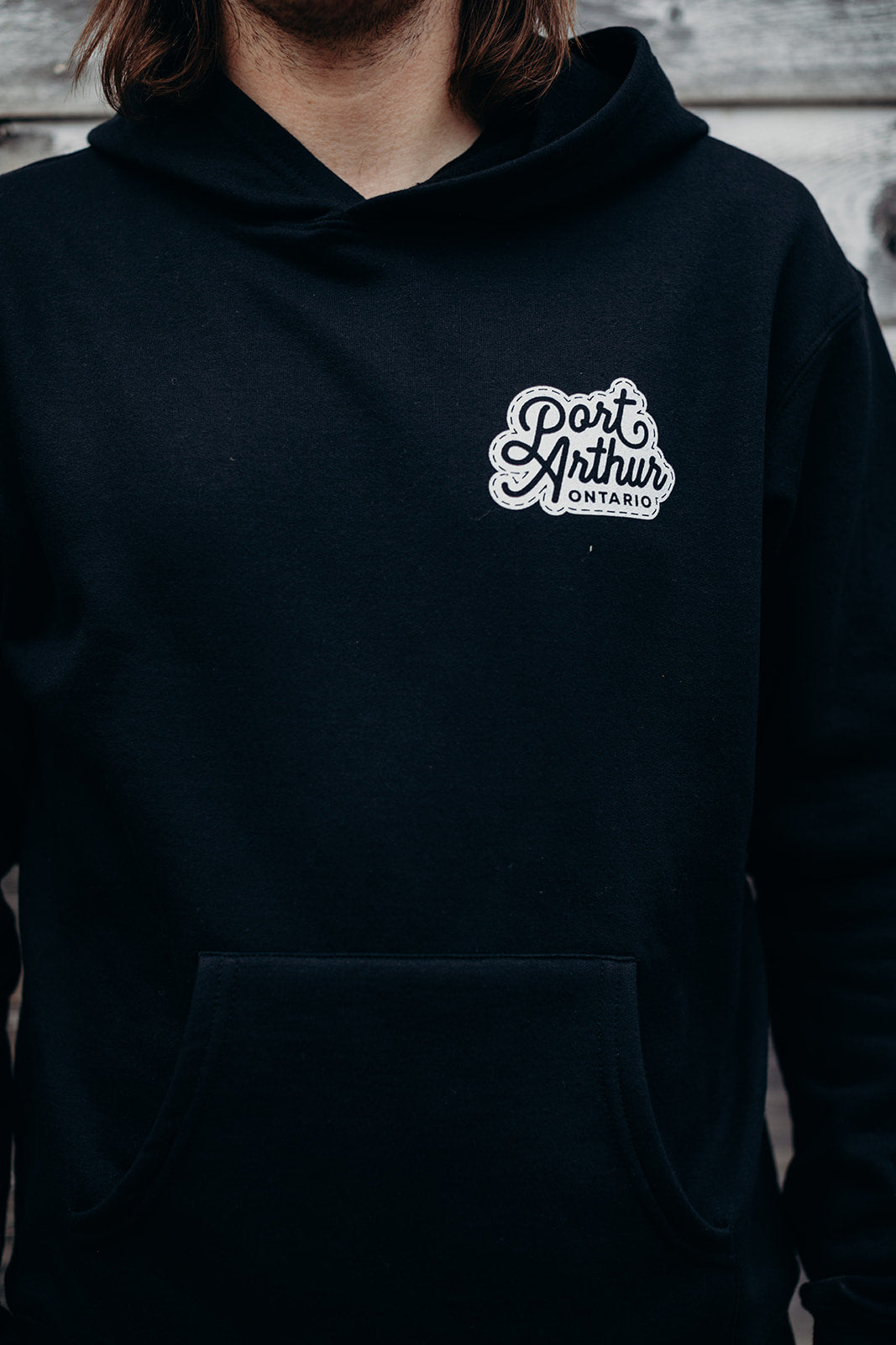 Black organic unisex hoodie with white 'Port Arthur' logo