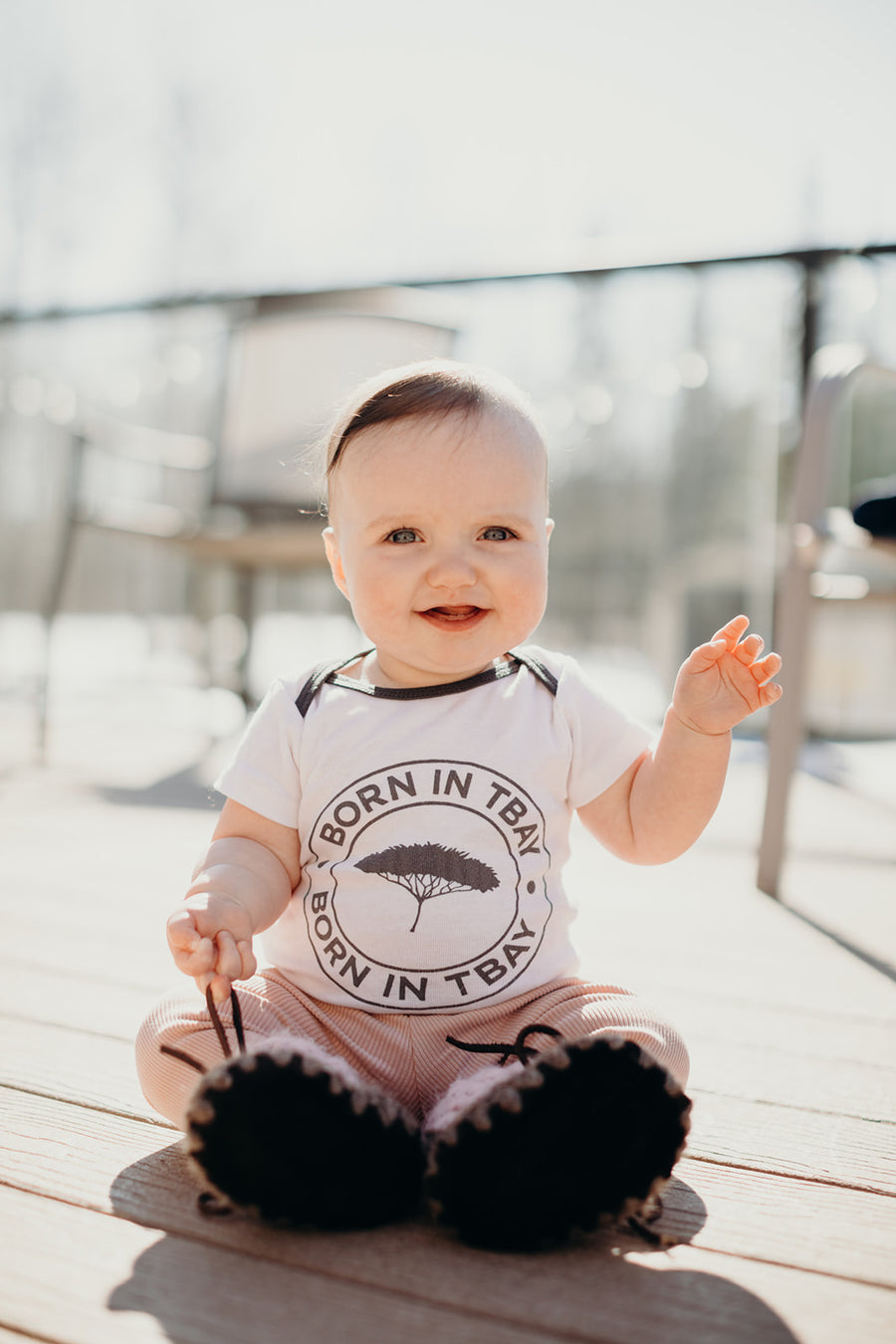 Organic baby onesie in white with grey "Born in Tbay" logo on front