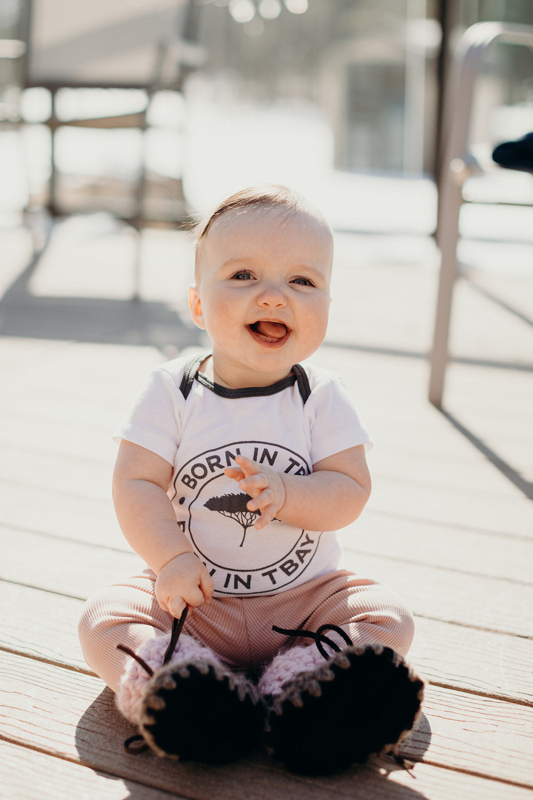 Organic baby onesie in white with grey "Born in Tbay" logo on front