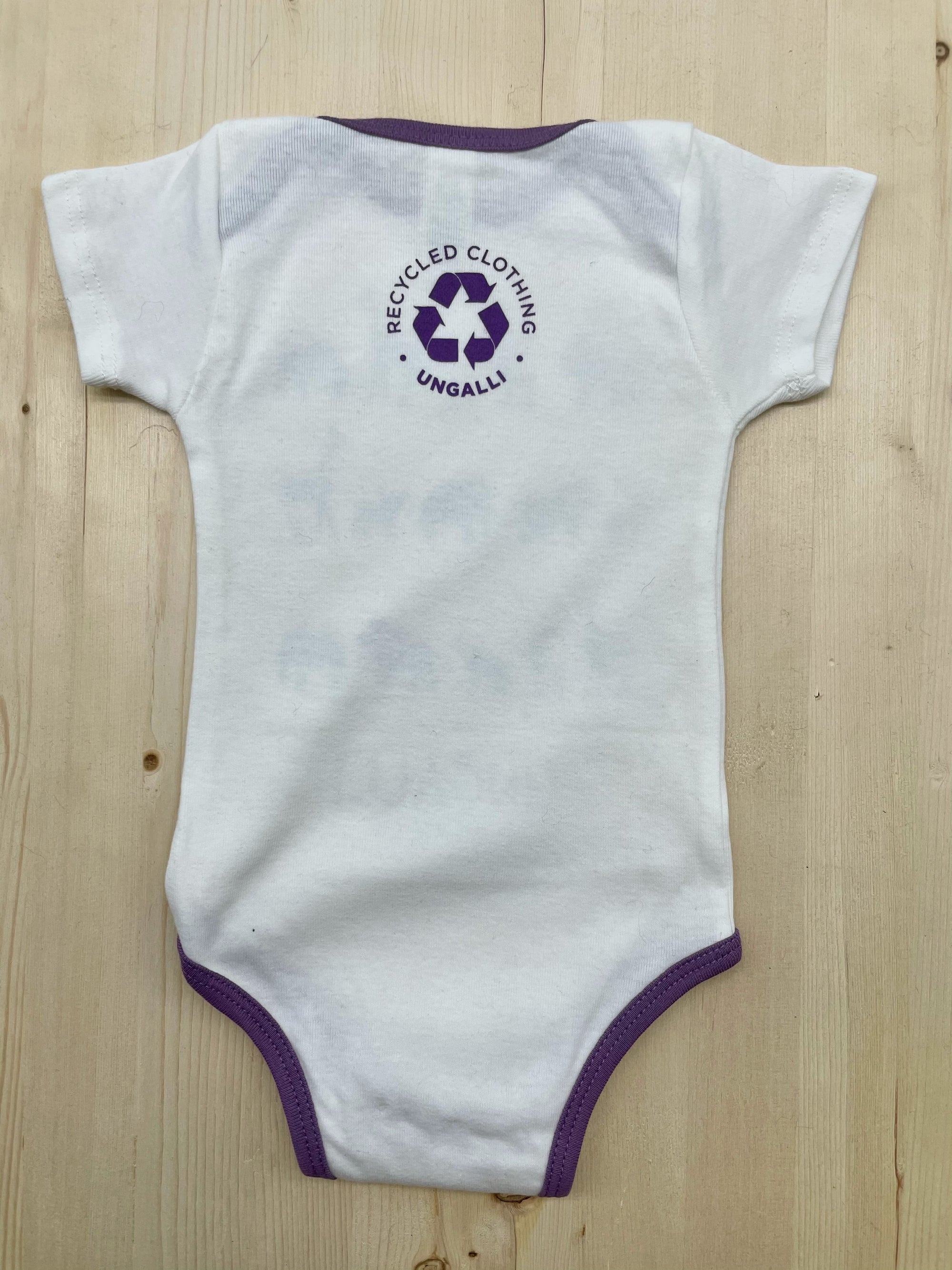 Organic baby onesie in white with purple accents and animal design
