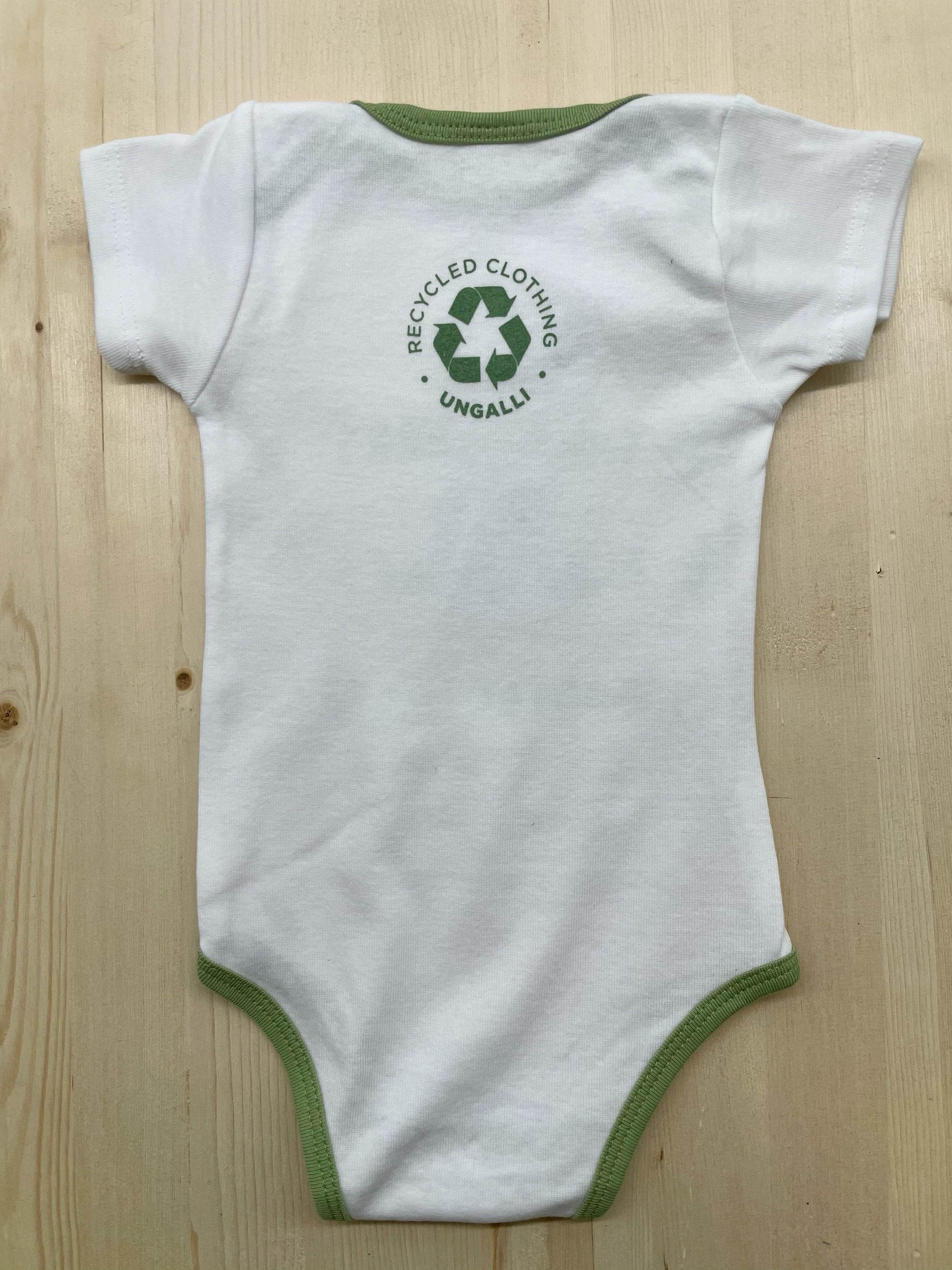 Babies organic onesie in white with green text that states: "Save the bees, plant trees & protect our seas"