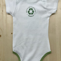 Babies organic onesie in white with green text that states: "Save the bees, plant trees & protect our seas"