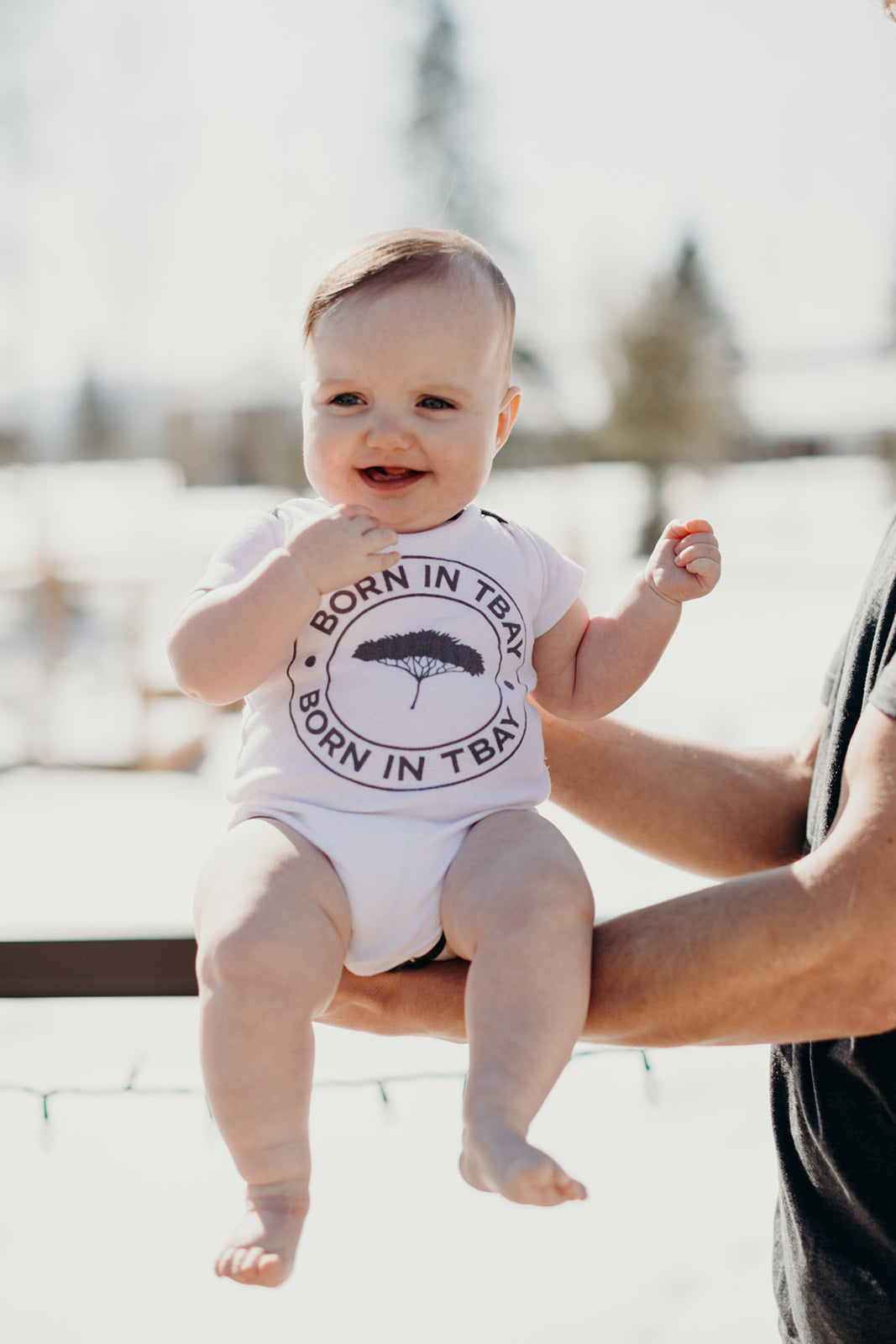 Organic baby onesie in white with grey "Born in Tbay" logo on front