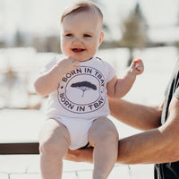 Organic baby onesie in white with grey "Born in Tbay" logo on front