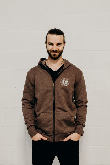 Brown ethically made unisex zip up hoodie with white "in our hands'" logo