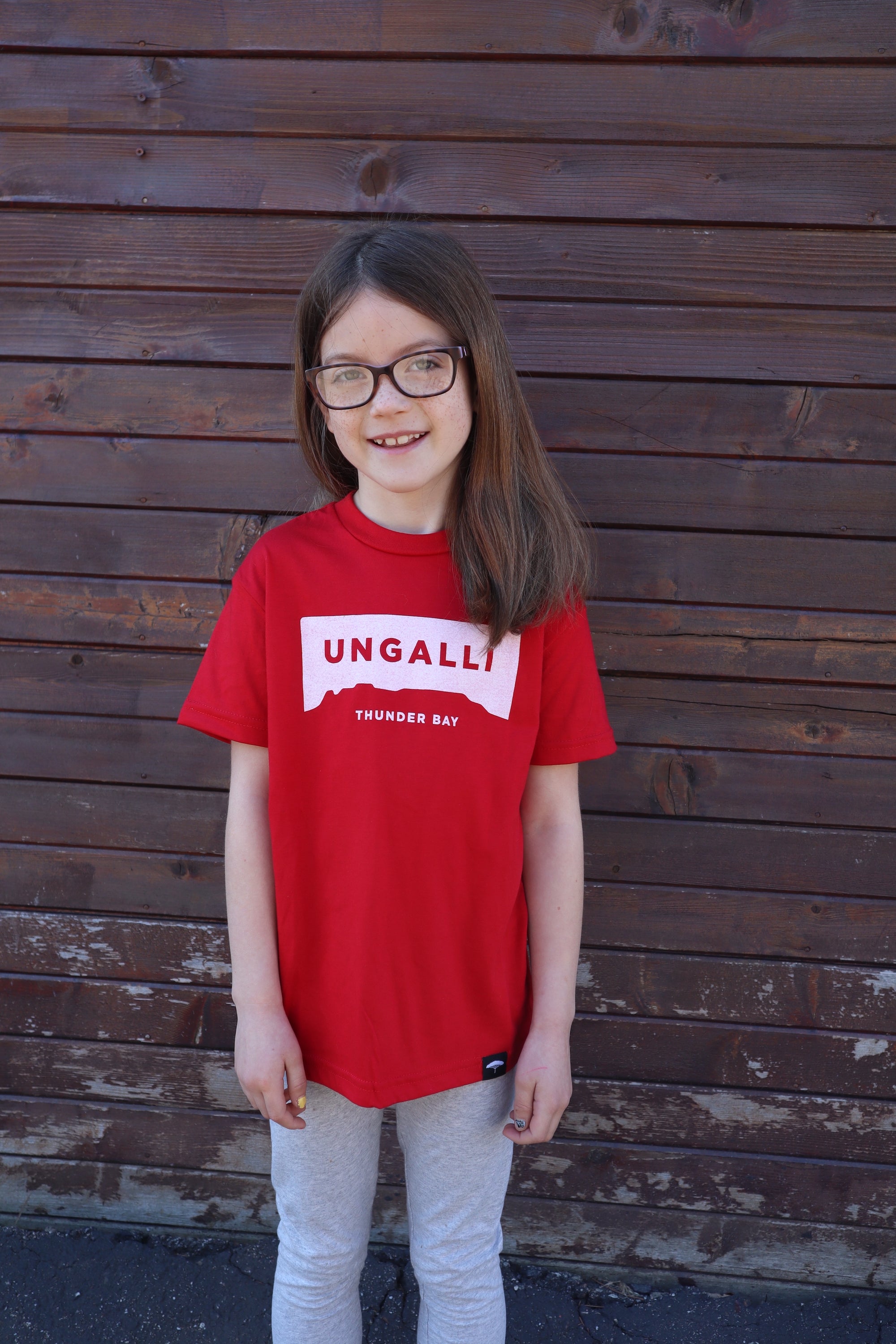 Children's recycled red t-shirt with white accents and sleeping giant outline across front