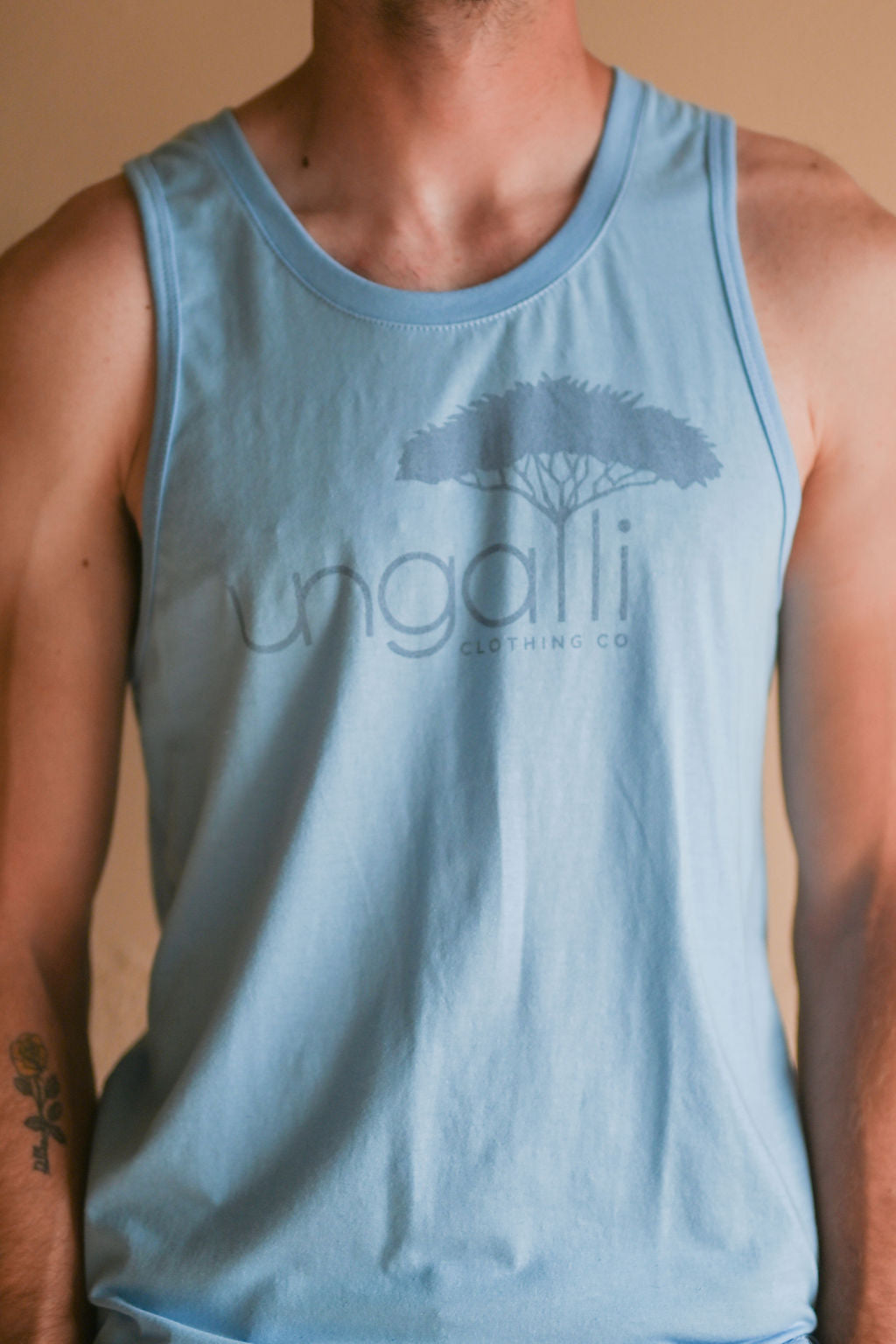 Light blue men's tank top with but Ungalli logo across front