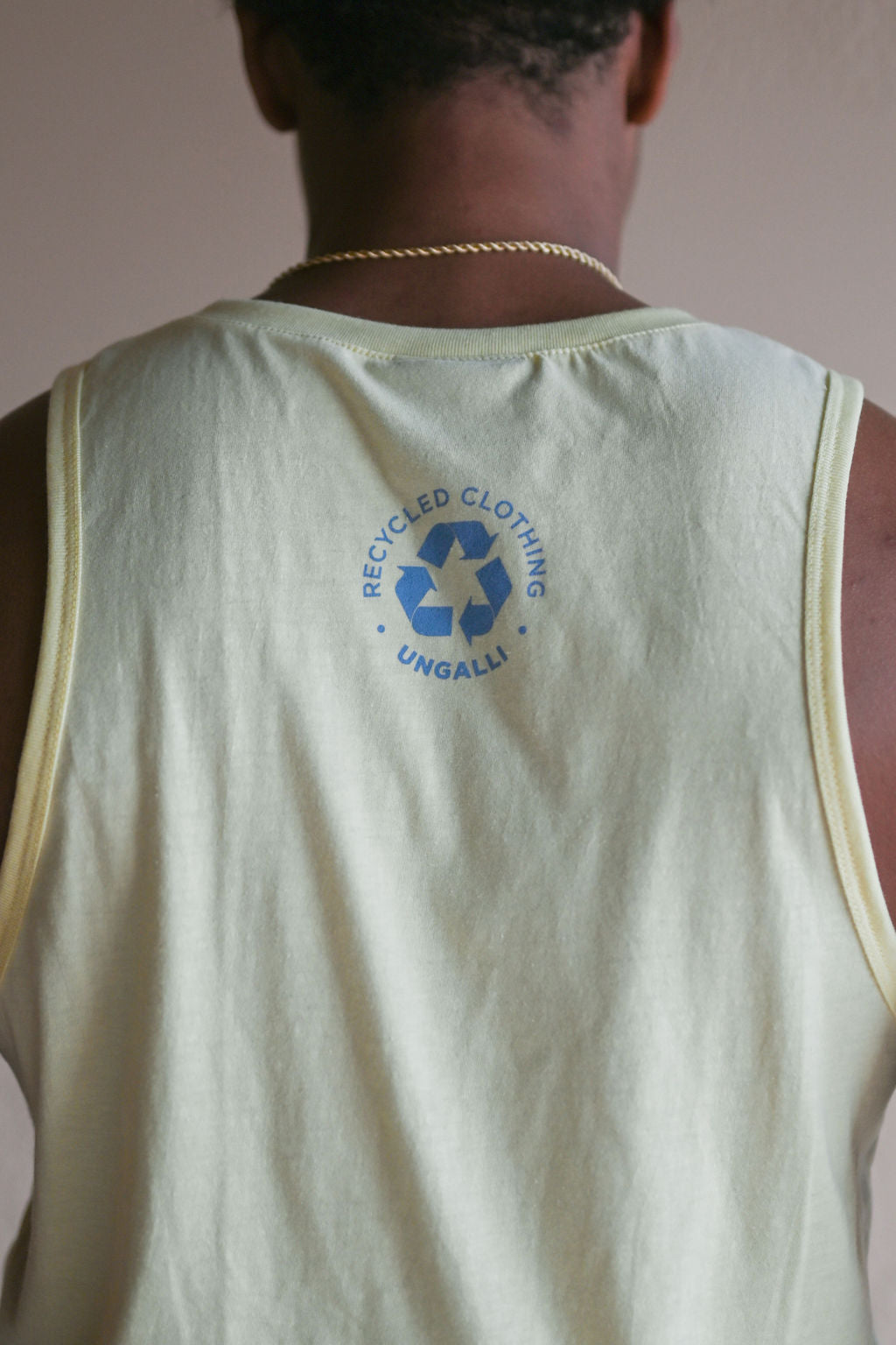 Men's recycled yellow tank top with light blue Ungalli logo across front