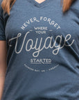 Women's short sleeve organic blue t-shirt with text reading: "Never forget where your voyage starts"