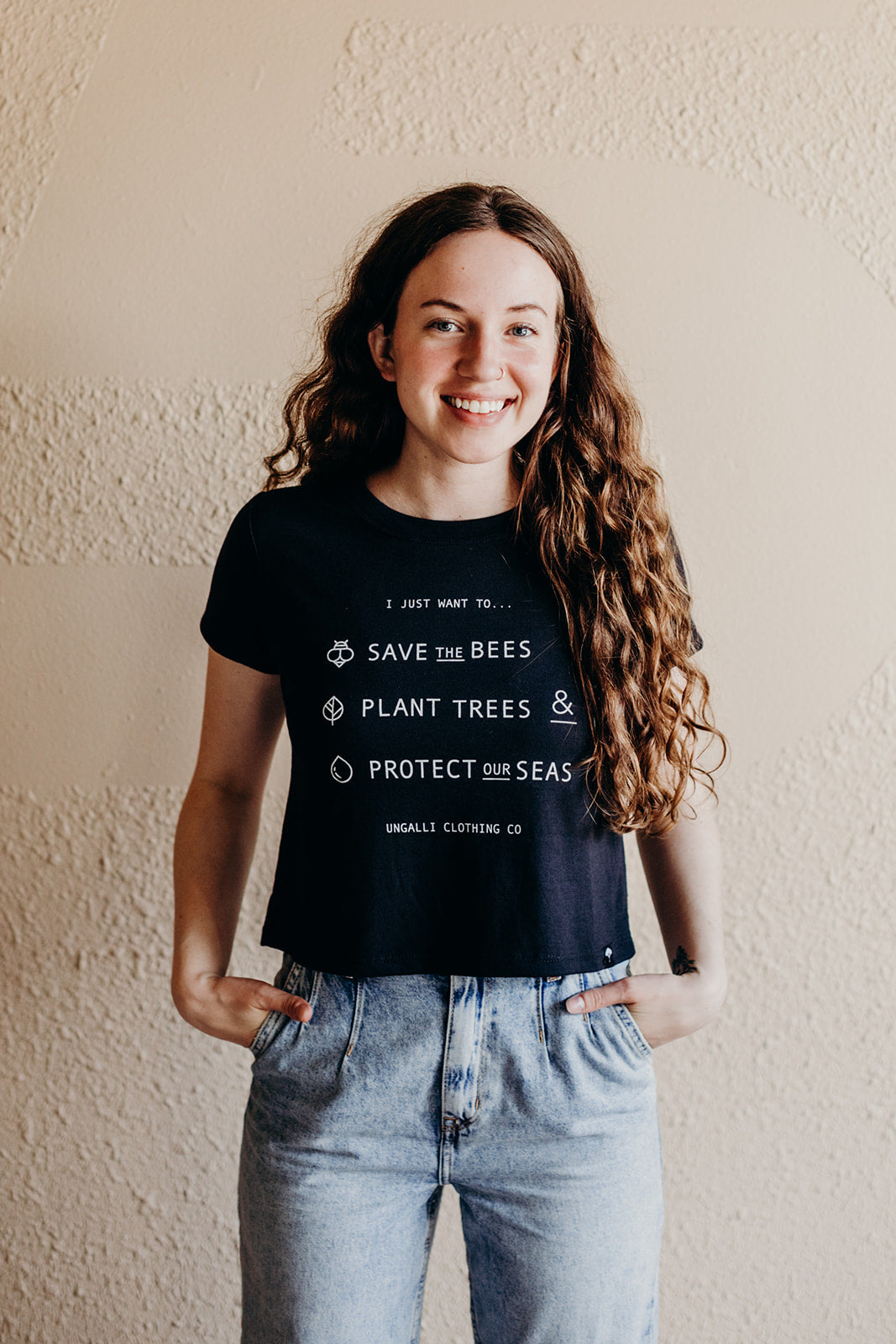 Women's organic black cropped t-shirt with text on front that reads: "I just want to save the bees, plant trees & protect our seas"