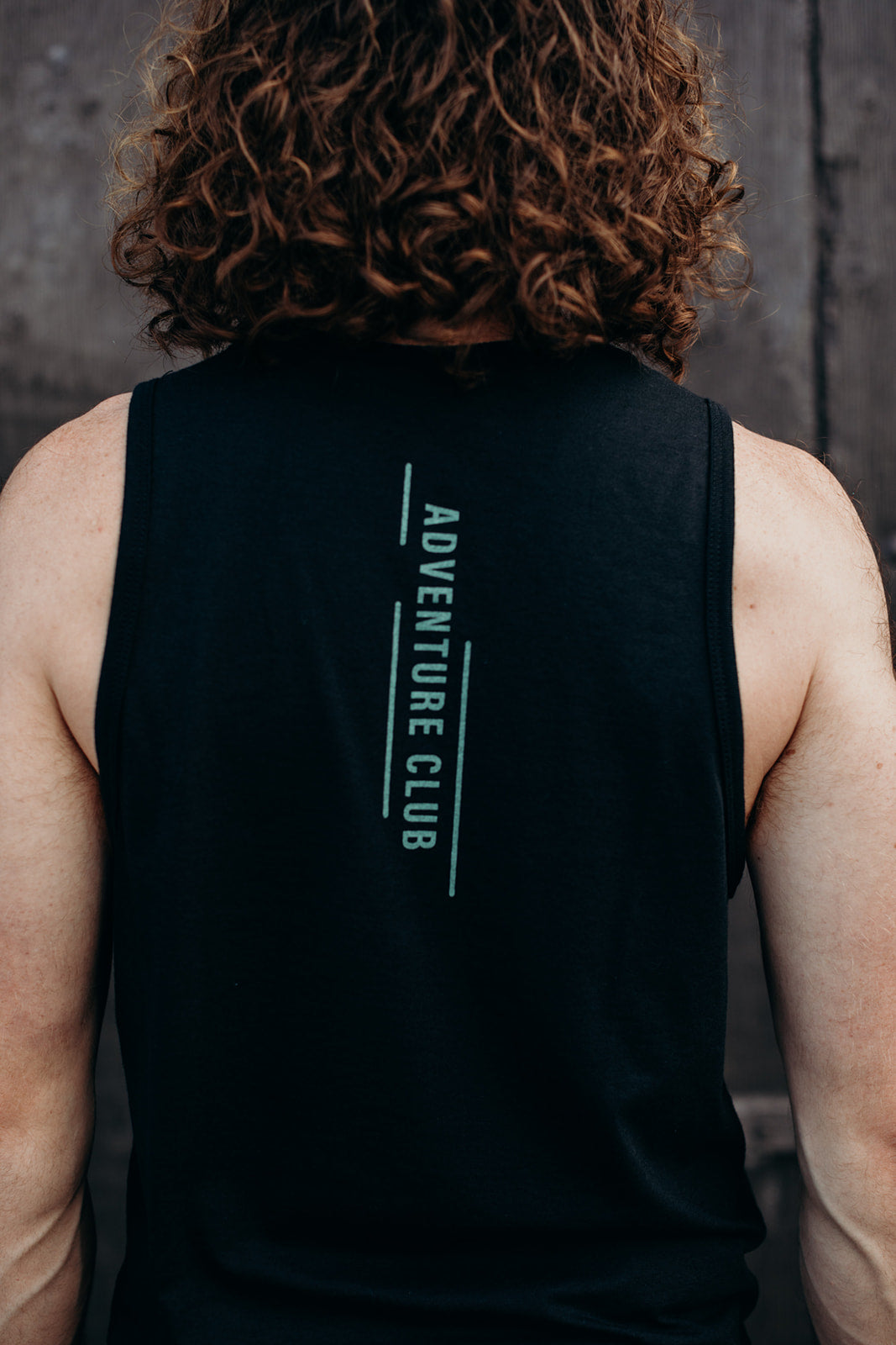Mens organic black tank top with adventure club multi coloured logo