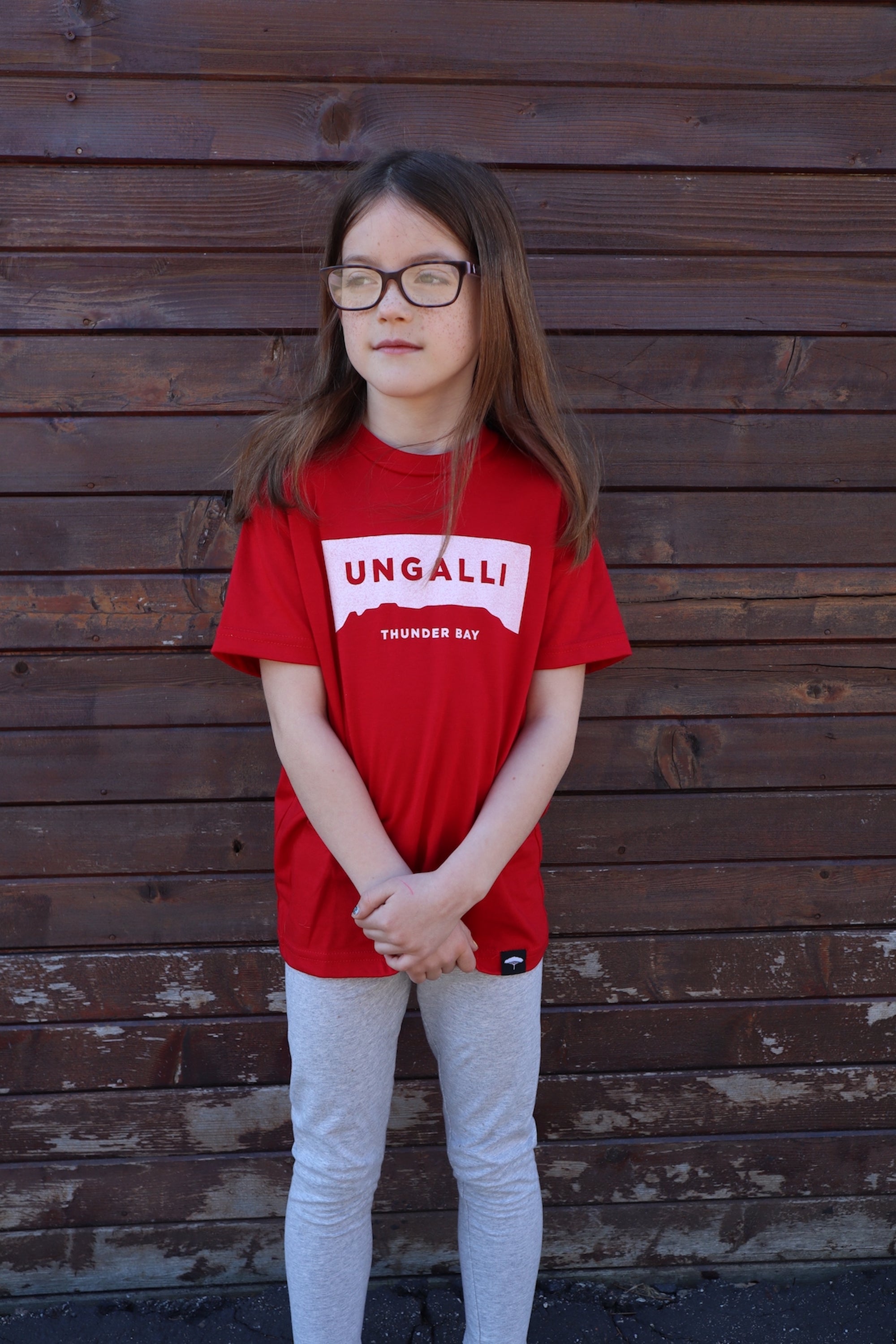 Children's recycled red t-shirt with white accents and sleeping giant outline across front