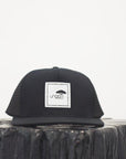 Unisex ethically made flat brim snapback hat in black or grey with white Ungalli logo on front