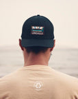 Unisex organic snap back hat in grey or black with multicoloured Ungalli/sleeping giant design on front