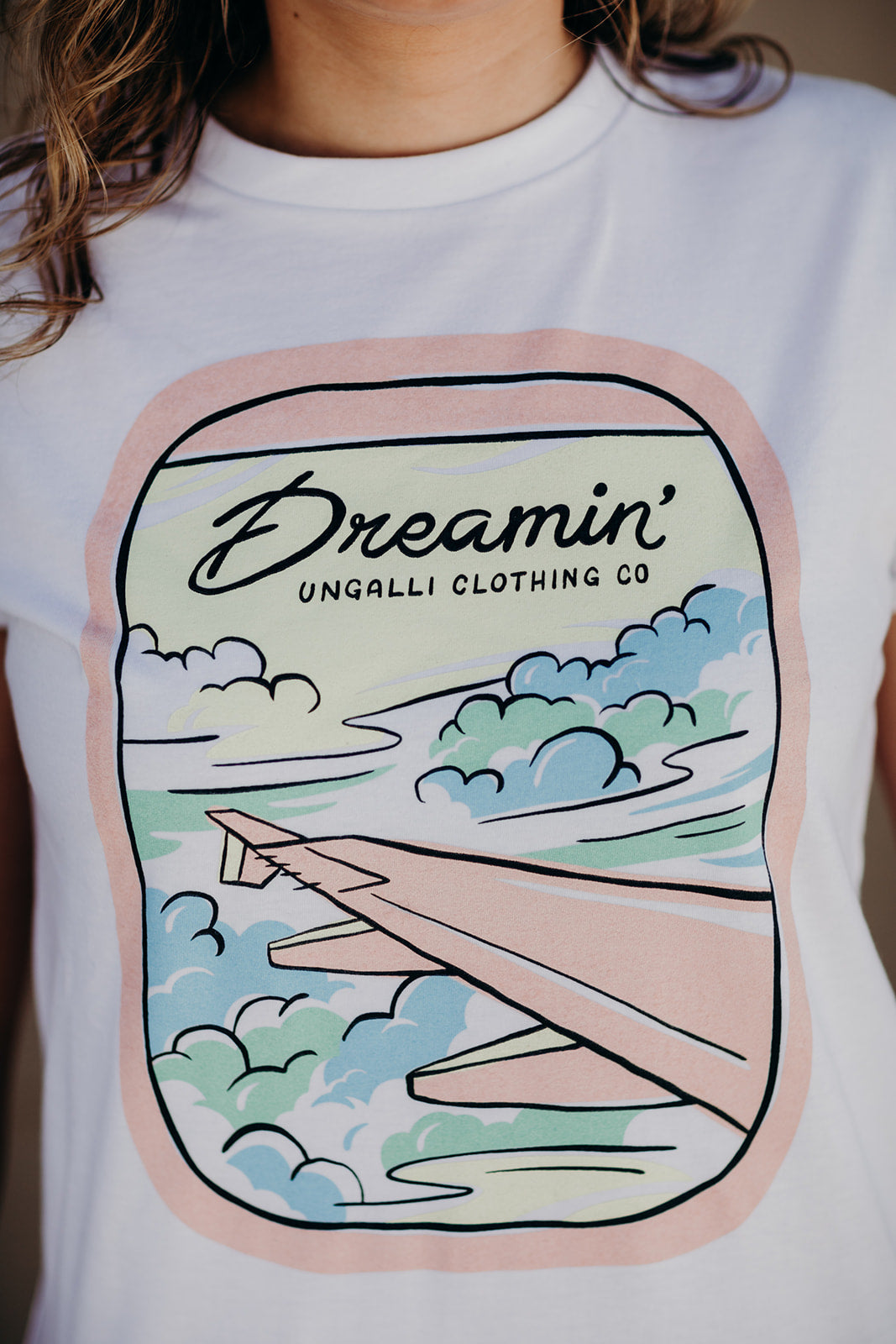 Organic white unisex t-shirt with multi-coloured dreamin' plane logo on front