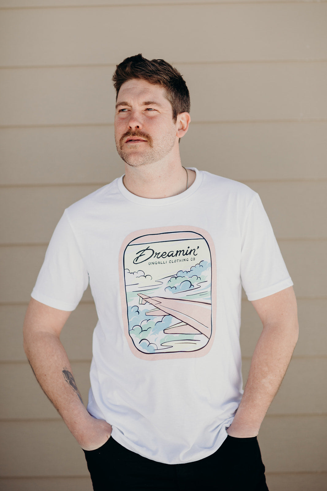 Organic white unisex t-shirt with multi-coloured dreamin' plane logo on front