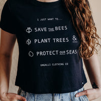 Women's organic black cropped t-shirt with text on front that reads: "I just want to save the bees, plant trees & protect our seas"